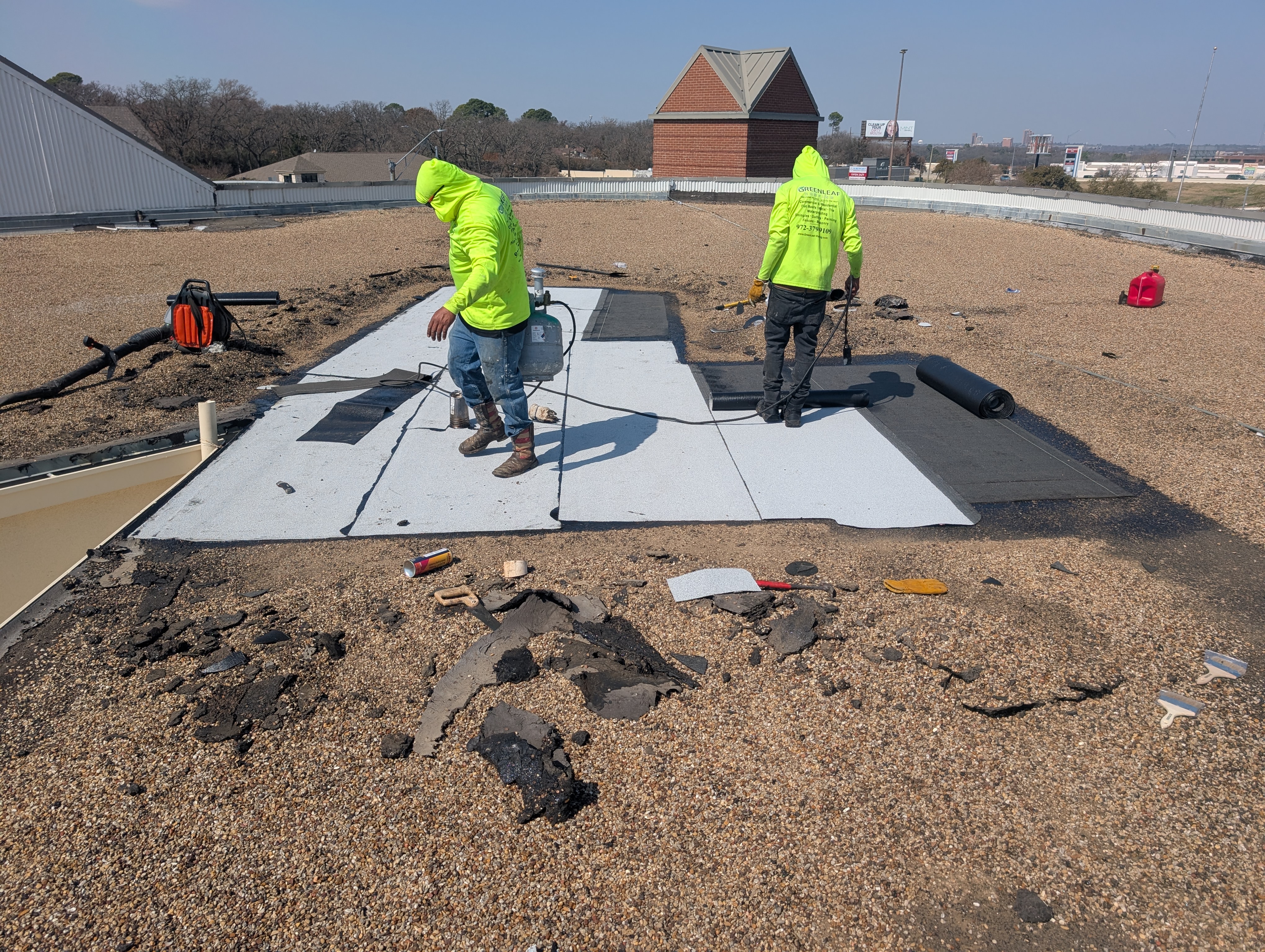 Commercial roof maintenance inspection being performed on flat roof